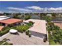 An aerial view of a beautiful single-Gathering home with a tile roof, lush landscaping, and waterfront access at 243 Hermosita Dr, St Pete Beach, FL 33706