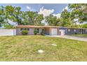Inviting single-story home with a well-maintained lawn, driveway, attached garage, and mature trees at 2933 Stratford Dr, Largo, FL 33771