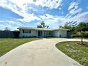 Inviting single-story home showcasing a circular driveway, lush lawn, and a well-manicured palm tree at 3300 58Th N St, St Petersburg, FL 33710