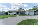 Charming single-story home with well-manicured lawn and circular driveway leading to an attached garage at 3300 58Th N St, St Petersburg, FL 33710