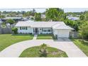 Charming single-story home featuring a well-manicured lawn and a circular driveway leading to an attached garage at 3300 58Th N St, St Petersburg, FL 33710