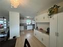 Well-lit kitchen with white cabinetry, modern appliances, and a view into an adjacent living area at 3300 58Th N St, St Petersburg, FL 33710