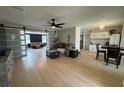 Bright, open-concept living room with hardwood floors, modern ceiling fan, and sliding barn doors at 3300 58Th N St, St Petersburg, FL 33710