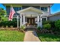 Inviting front entrance featuring a covered porch, double doors, decorative flower pots, and lush landscaping at 3304 Latania Dr, Tampa, FL 33618