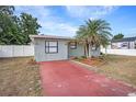 Inviting single-story home with a red driveway, mature palms, and a well-maintained front yard at 3308 W Walnut St, Tampa, FL 33607