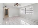 Bright living room featuring tile flooring, a ceiling fan and a large window at 3308 W Walnut St, Tampa, FL 33607