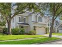 Traditional two-story home with white brick and siding, lush landscaping, and a bench in the front yard at 3619 W Leona St, Tampa, FL 33629