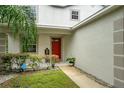 Inviting front entrance featuring a bright red door, well-manicured landscaping and neutral paint colors for curb appeal at 396 Winthrop Dr, Spring Hill, FL 34609