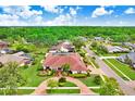 Aerial view of a lovely neighborhood featuring a home with mature trees and a red brick driveway at 5112 Lanai Way, Tampa, FL 33624