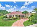 Charming one-story home featuring a red brick driveway and well-maintained landscaping at 5112 Lanai Way, Tampa, FL 33624