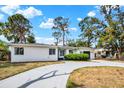 Classic single-story home with a gray driveway, minimalist landscaping, and a stylish blue door at 6120 5Th N Ave, St Petersburg, FL 33710