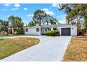 Beautiful single-story home with a gray driveway, lush landscaping, and a sleek gray garage door at 6120 5Th N Ave, St Petersburg, FL 33710