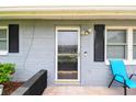 Close-up of the front door with black shutters and light fixture at 6246 Bandura Ave, New Port Richey, FL 34653