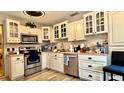 Bright kitchen featuring stainless steel appliances, ample cabinet space, and wood-look flooring at 7012 Pin Cherry Ln, Port Richey, FL 34668