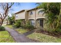 Inviting townhouse featuring lush landscaping and a charming covered entryway at 7606 Woodbridge Blvd, Tampa, FL 33615