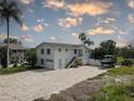 Beautiful exterior of a two-story home with a brick driveway and lush tropical landscaping at 8117 Bay Dr, Tampa, FL 33635