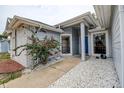 Inviting entrance with lovely plants, stone landscaping, and a bright blue front door at 8913 Welsh Way, Hudson, FL 34667
