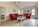 Bright living room featuring a vaulted ceiling and neutral paint with red sofas at 8913 Welsh Way, Hudson, FL 34667