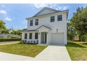 Charming two-story home with white siding, black trim, manicured lawn and driveway at 925 E Chelsea St, Tampa, FL 33603