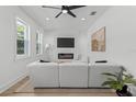 Bright living room with fireplace, TV, modern white sectional, and natural light at 925 E Chelsea St, Tampa, FL 33603