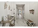 Bright, modern hallway with marble floors, stylish decor, and convenient storage at 1003 Bellasol Way # 9203, Apollo Beach, FL 33572