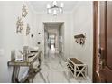 Elegant hallway featuring marble floors, modern decor, and a decorative chandelier at 1003 Bellasol Way # 9203, Apollo Beach, FL 33572