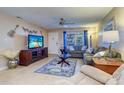 Cozy living room with tile flooring, ceiling fan, decorative touches, and ample natural light at 10037 62Nd N Ter # 9, St Petersburg, FL 33708