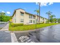 A tan two-story condo with green lawns and palm trees at 1100 E Bay Dr # 60, Largo, FL 33770