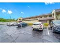 The exterior showcases ample parking and well-maintained landscaping around the two-story condo building at 1100 E Bay Dr # 60, Largo, FL 33770