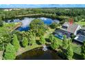 Expansive backyard with a screened-in pool, jacuzzi, and private dock on a serene lake at 11320 Lazy Hickory Ln, Tampa, FL 33635