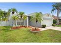 Eye-level shot of a single-story home featuring a well-maintained lawn, mature palm trees, and a two-car garage at 11619 Fox Creek Dr, Tampa, FL 33635