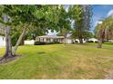 Charming single-story home with a well-manicured lawn, trees, and a one-car garage at 119 N Hillcrest Ave, Clearwater, FL 33755