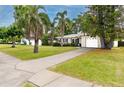 Charming single-story home with a well-manicured lawn, palm trees, and a one-car garage at 119 N Hillcrest Ave, Clearwater, FL 33755