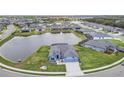Aerial view of a blue home on a pond with a fenced in backyard at 12710 Wheatgrass Ct, Parrish, FL 34219