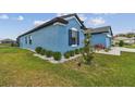 Landscaped side yard with decorative rock and a view of the blue home's exterior at 12710 Wheatgrass Ct, Parrish, FL 34219
