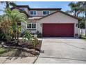 Charming two-story home features a two-car garage and a well-manicured front yard with tropical landscaping at 1313 Key West Ct, Wesley Chapel, FL 33544