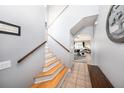 Bright hallway with wood staircase leading to an open living area, enhanced by a neutral color palette at 1313 Key West Ct, Wesley Chapel, FL 33544