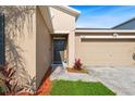 Home's entryway features a modern front door, green lawn, and an attached two-car garage at 15507 Caynor Ash Ln, Sun City Center, FL 33573