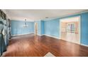 Bright living room with wood floors, blue walls, and natural light from large windows at 16201 Country Crossing Dr, Tampa, FL 33624