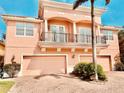 Charming two-story home featuring a double balcony, three-car garage, and brick-paved driveway at 184 Banyan Bay Dr, St Petersburg, FL 33705