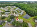 Aerial view of the home nestled in a community surrounded by lush green spaces and a serene lake at 1902 Hanson Ct # 308, Sun City Center, FL 33573