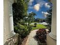 Inviting walkway to front door with lush landscaping and exterior pillars at 2349 Wood Pointe Dr, Holiday, FL 34691