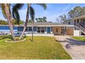 Inviting single-story home with a blue accent wall, lush lawn, and a convenient carport at 306 12Th Ave, Indian Rocks Beach, FL 33785