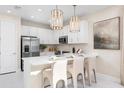 Bright modern kitchen featuring white cabinets, stainless steel appliances, and a large island with seating at 3198 Malta Ave, Wesley Chapel, FL 33543