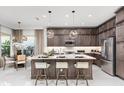 Modern kitchen with stainless steel appliances, center island with seating, and stylish pendant lighting at 32523 Neroli St, Wesley Chapel, FL 33543