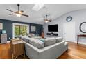 A sun-drenched living room features a gray sectional, skylight, and sliding glass doors to the outside at 3668 Pond View Ln, Sarasota, FL 34235