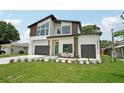 Contemporary home with multi-car garage, green lawn, and stylish design at 3817 W San Nicholas St, Tampa, FL 33629