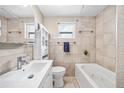 Bright bathroom featuring a sleek vanity, tiled walls, and a tub with a jacuzzi jet system at 4601 83Rd N Ave, Pinellas Park, FL 33781