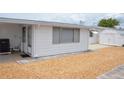Features a clean exterior with an enclosed shed for storage and a gravel yard, offering a low-maintenance outdoor space at 4922 Genesis Ave, Holiday, FL 34690