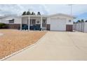Single-story home boasts a covered porch, attached garage, and long driveway leading to a well-manicured yard at 4922 Genesis Ave, Holiday, FL 34690